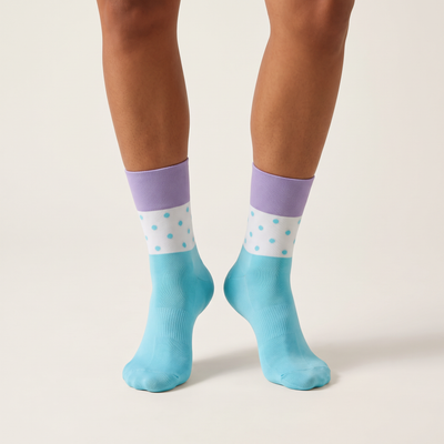 Polka Dot mid-length cycling socks on feet, front view, light blue foot, white polka dot band and lilac cuff